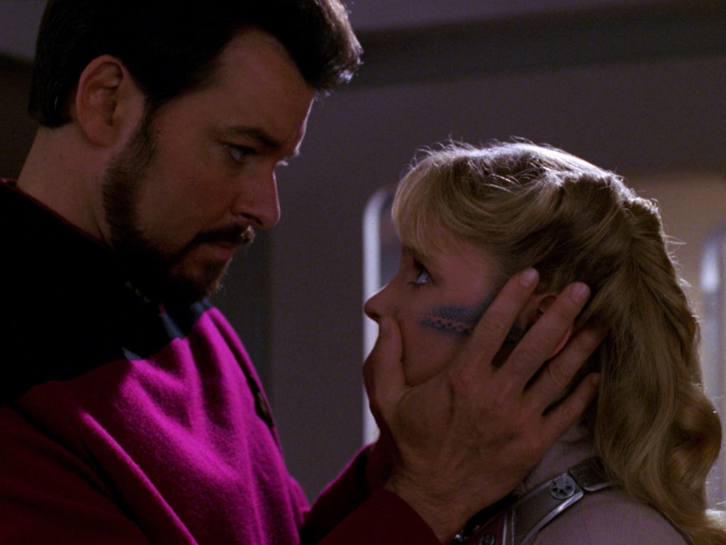 Riker holds Yuta's face as if comforting her