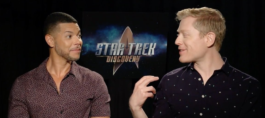 Wilson Cruz and Anthony Rapp looking fondly at each other in an interview.