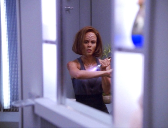 B'Elanna looks at herself in the mirror healing her injured arm