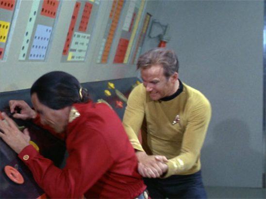 Kirk hits Khan in the back with two fists
