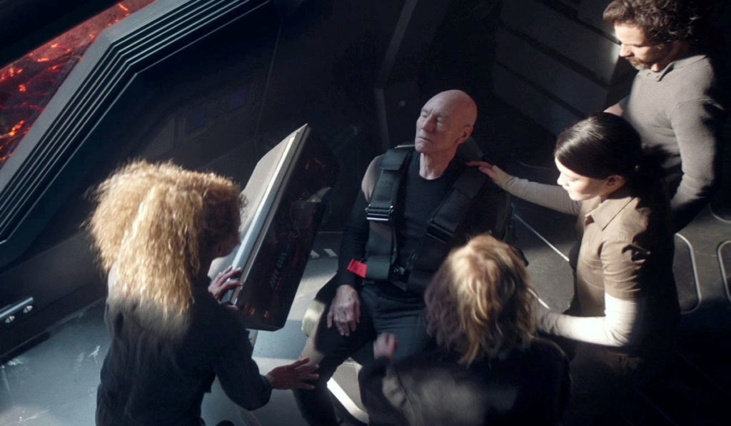 The crew rushes to Picard's side