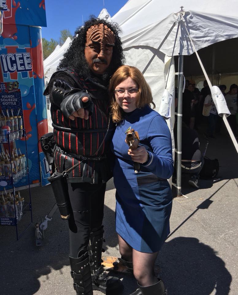 Klingon cosplayer and the author in a Starfleet cosplay, pointing at the camera