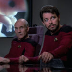 Riker and Picard in the conference room in front of the viewscreen showing Troi's fetus
