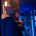 Geordi and Alandra La Forge looking at a console