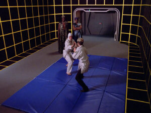 Tasha Yar faces off in a martial arts competition in the holodeck, while Lutan watches, in "Code of Honor"